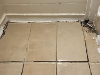 Bathroom floor with damaged grout before regrouting